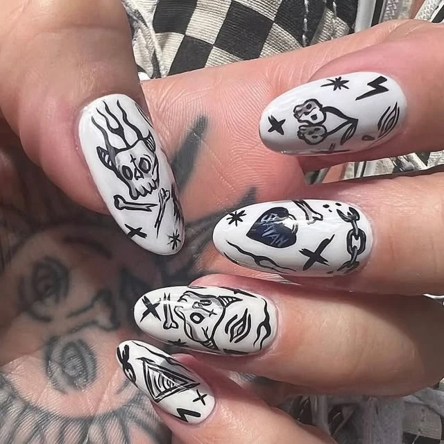 White nails with black hand-painted illustrations
